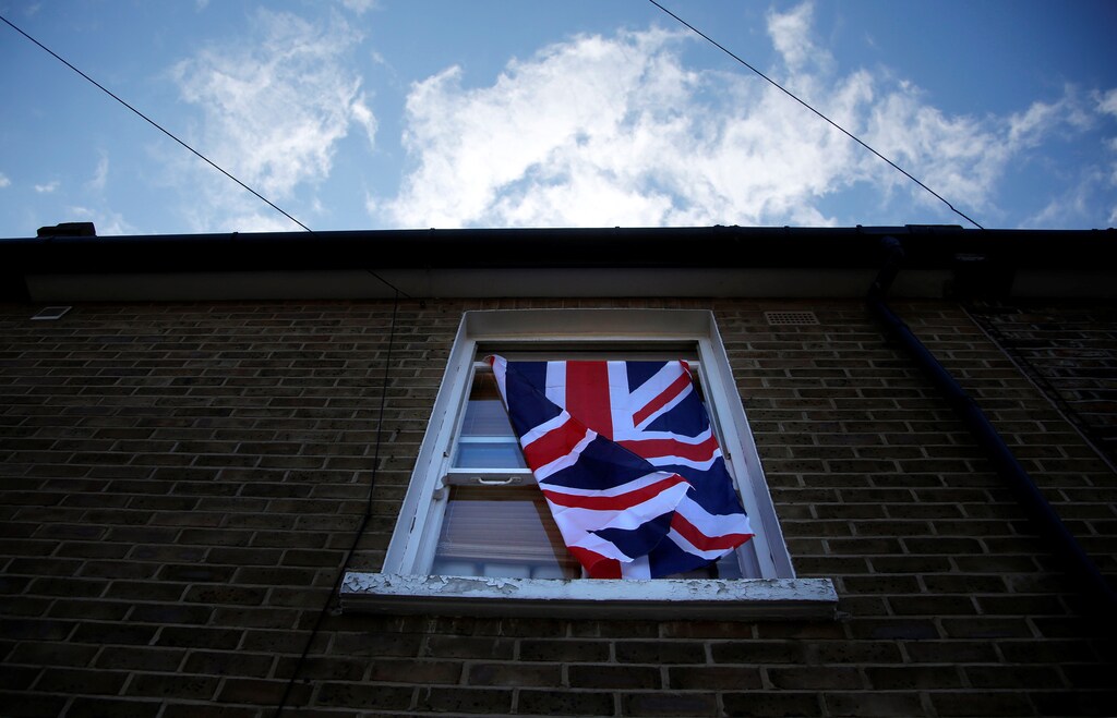 A British flag flutters in front of a window in London
