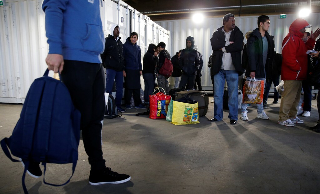 Migrants wait for a bus to leave the reception center for migrants and refugees near porte de La Chapelle in the north of Paris, France, November 25, 2016. The brand new 400-bed reception centre welcomes migrants giving them temporary refuge until French authorities find them a more permanent solution. Picture taken November 25, 2016. REUTERS/Jacky Naegelen - RTSUP1L