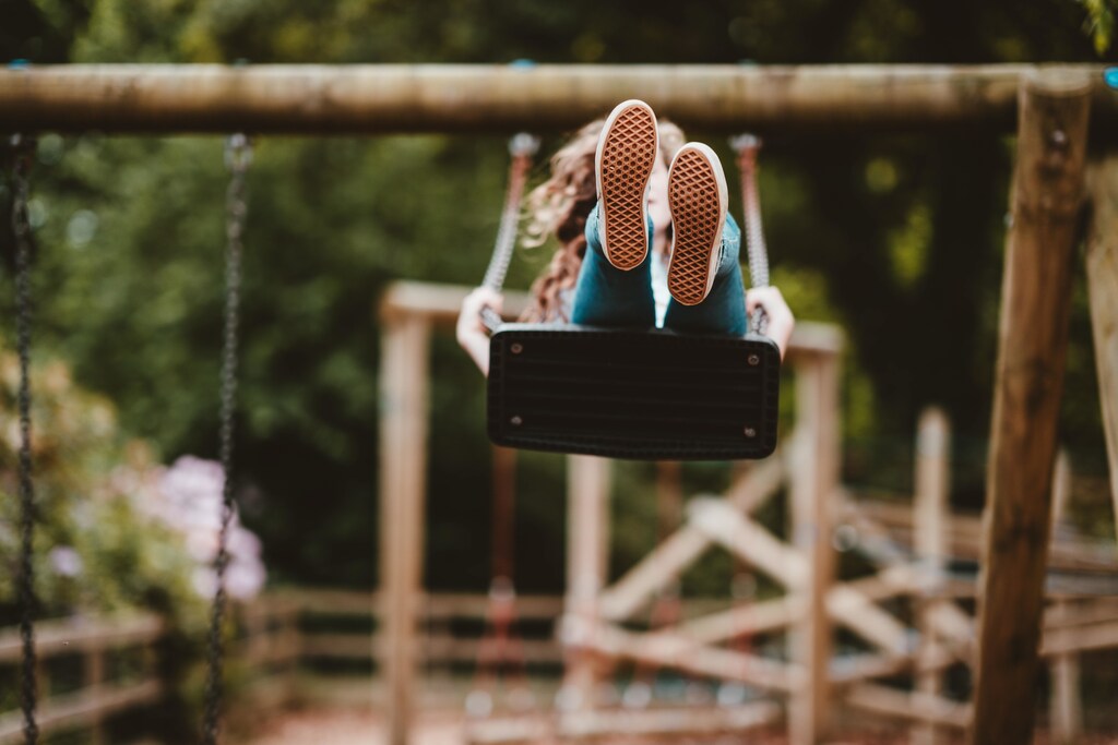 this girl is playing on a swing outside. The company AirBubble has designed a new children's play pavilion that reduces pollution