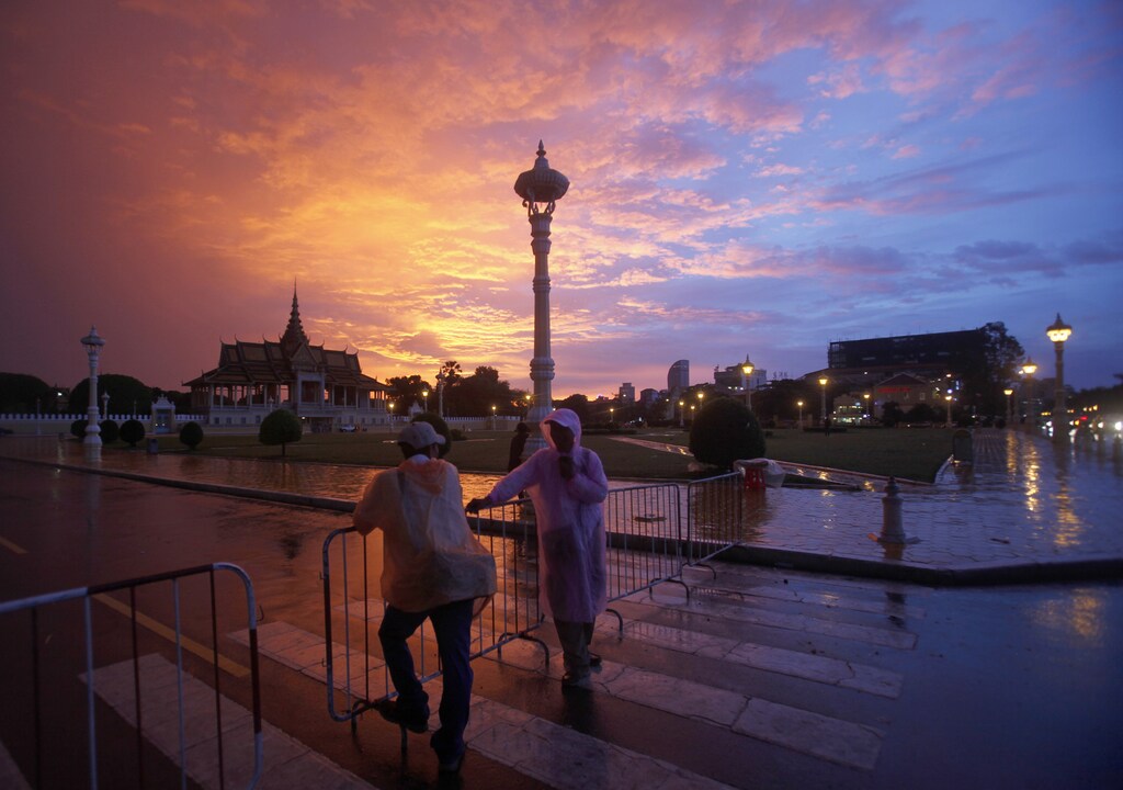 Men stand in front of the Royal Palace in Phnom Penh September 4, 2014.