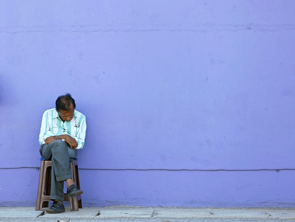 A man falls asleep while sitting next a shop on a main road in Colombo, Sri Lanka May 2, 2016. REUTERS/Dinuka Liyanawatte - S1BETBRQZCAA