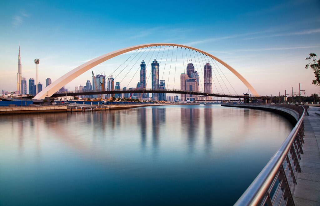 DUBAI, UAE - FEBRUARY 2018: Colorful sunset over Dubai Downtown skyscrapers and the newly built Tolerance bridge as viewed from the Dubai water canal.