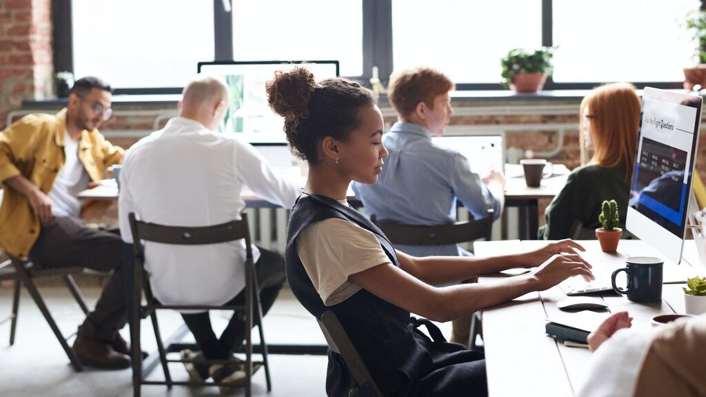 black women typing in the foreground, other workers in the background