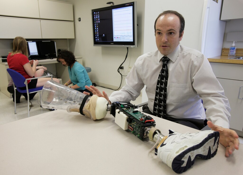 Research scientist Levi Hargrove describes a robotic prosthesis at the Rehabilitation Institute of Chicago's Center for Bionic Medicine, April 13, 2011. Hailey Daniswicz, a sophomore at Northwestern University who her lost her lower leg to bone cancer, is training a computer to recognize slight movements in her thigh so she can eventually be fitted with a "bionic" leg - a robotic prosthesis she would control with her own nerves and muscles. Daniswicz is part of a clinical trial sponsored by the U.S. Army that is using electromyography - electrical signals produced by muscles - and pattern recognition computer software to control a new generation of robotic limbs. Picture taken April 13, 2011. REUTERS/John Gress (UNITED STATES - Tags: HEALTH SCI TECH) - GM1E74L06J601