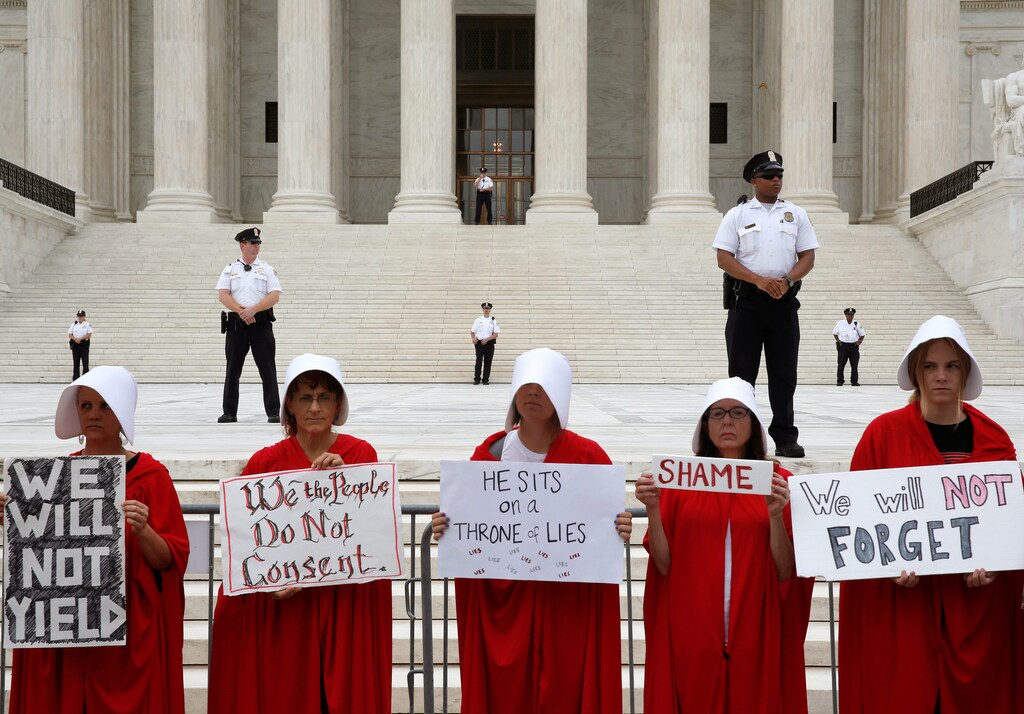 Police watch over protesters as they demonstrate on first day with newly sworn in Associate Justice Brett Kavanaugh on the court at the Supreme Court in Washington, U.S., October 9, 2018. REUTERS/Joshua Roberts - RC1434407600