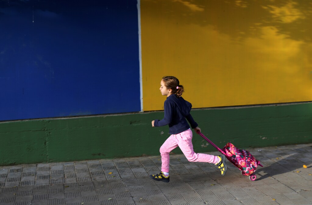 ATTENTION EDITORS: SPANISH LAW REQUIRES THAT THE FACES OF MINORS ARE MASKED IN PUBLICATIONS WITHIN SPAIN A school girl runs to school in Tomares, southern Spain November 3, 2016. REUTERS/Marcelo del Pozo - RTX2ROKO