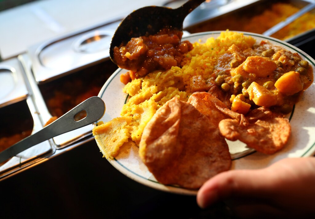 A customer self-serves a plate of food inside the 'Indian Veg' vegetarian restaurant in north London, Britain, January 28, 2017. REUTERS/Hannah McKay - RC1F960ED7F0