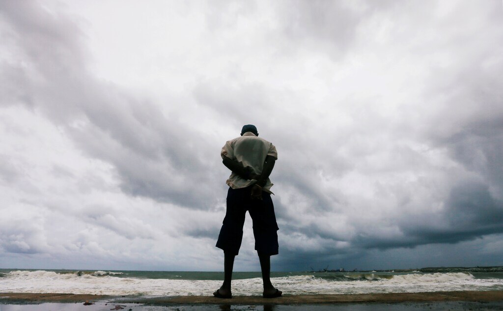 A man looks at the rough sea as rainy clouds gather above during the monsoon period in Colombo, Sri Lanka May 21, 2018. REUTERS/Dinuka Liyanawatte TPX IMAGES OF THE DAY - RC1636094500