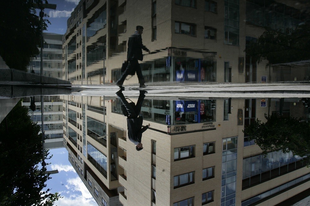 A businessman avoids puddles at the International Financial Services Centre - the business district of Dublin May 27, 2007. Picture was rotated 180 degrees.