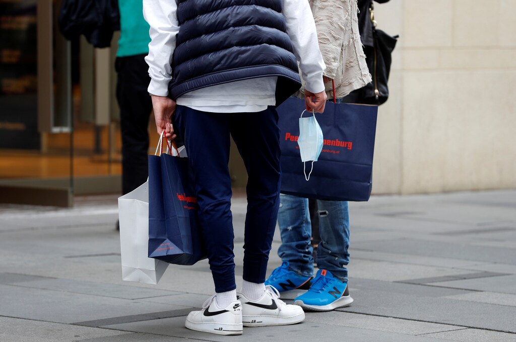 A customer holding a face mask leaves a shop after the government reopens bigger shops as well as small businesses in a loosening of the lockdown due to the coronavirus disease (COVID-19) outbreak, in Vienna, Austria May 2, 2020. REUTERS/Leonhard Foeger - RC2AGG9I3YNA
