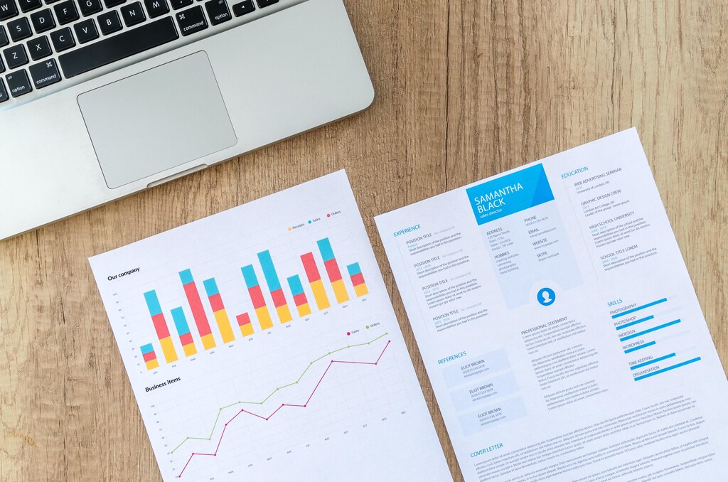 Two pieces of paper: one detailing company performance and the other a CV