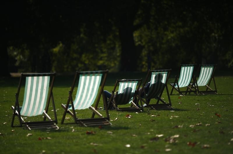 Visitors enjoy the autumn sunshine as they sit in deck chairs in St James Park, central London September 30, 2014. September is on course to be the driest since records began in 1910, according to Britain's Met Office. REUTERS/Andrew Winning (BRITAIN - Tags: ENVIRONMENT) - GM1EA9U1P7L01