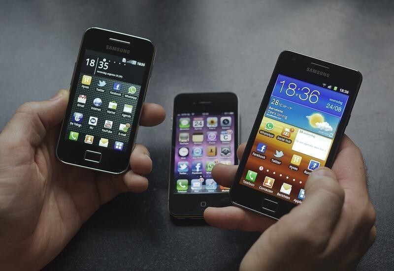 A man holds a Samsung S II (R) and Samsung Ace (L) smartphones next to an Apple iPhone 4 in Houten in this photo illustration August 24, 2011.Apple won an injunction in a Dutch court on Wednesday to stop Samsung Electronics from marketing three smartphone models in some European countries after alleging a breach of patents. Apple, which has conquered the high end of the phone market with its iPhone, argued that Samsung had infringed on three of its patents. The court ruled that Samsung smartphones Galaxy S, S II and Ace breached just one of Apple's patents. The Apple patent allows for a certain method of scrolling or browsing through photos in some Samsung smartphones, the court added.