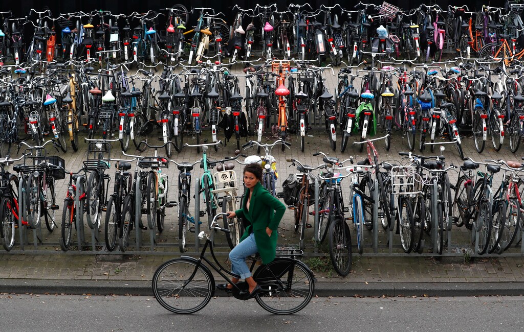 A cyclist rides past a big bike parking near Amsterdam Central Station in Amsterdam, Netherlands September 26, 2017. REUTERS/Yves Herman - RC19B3DBAF10