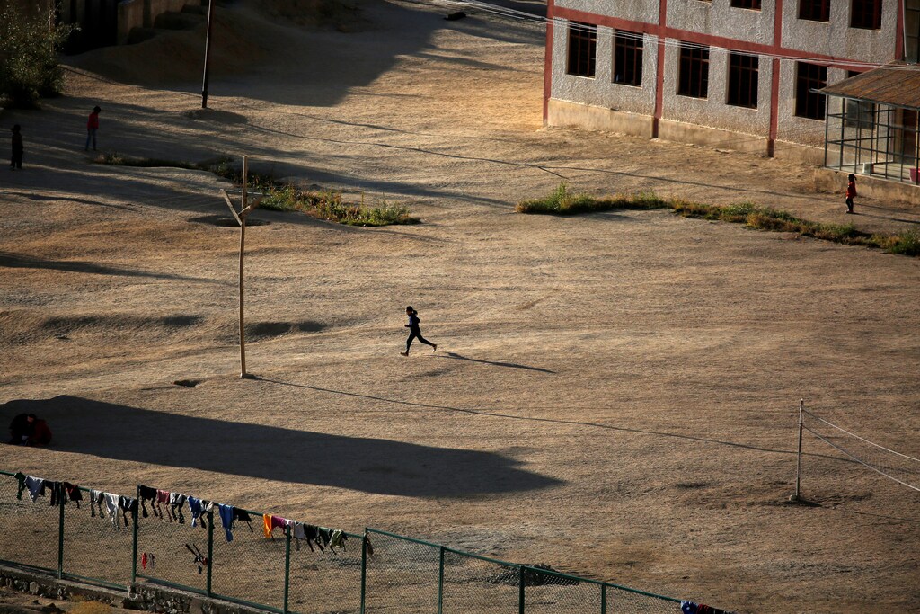 A girl runs across a school playground as the sun sets in Leh, the largest town in the region of Ladakh, nestled high in the Indian Himalayas, India September 24, 2016. REUTERS/Cathal McNaughton SEARCH "LADAKH" FOR THIS STORY. SEARCH "WIDER IMAGE" FOR ALL STORIES. - RTSRWTP