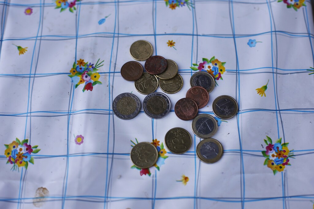 Coins are laid on a picnic table to buy lunch at a protest camp in Madrid, June 12, 2013. Members of the Asamblea de Parados de Fontarron (Unemployed assembly of Fontarron), most of them unemployed, set up a camp site late Saturday June 8, 2013 at the public park of their neighbourhood in Fontarron, Madrid, to protest against Spain's unemployment and the government's labour reform. At 27 percent in the first quarter, Spain's unemployment rate is the highest in the European Union after Greece, and even if the country pulls out of recession next year as economists forecast, job creation could lag for some time longer. The camp site was dismantled early June 13, 2013 by police on the grounds that it was illegal. Picture taken June 12, 2013. REUTERS/Susana Vera (SPAIN - Tags: SOCIETY CIVIL UNREST) - GM1E96E00UQ01