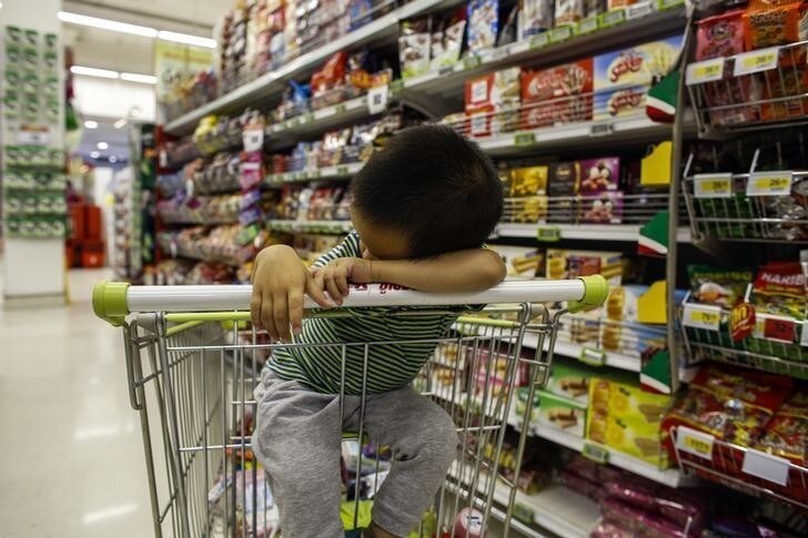 A boy sleeps in a shopping cart at a department store in Bangkok October 29, 2013. The Thai economy has struggled free of recession, but latest data is hardly encouraging for a government that is banking on a recovery in slumping exports to offset the heavy cost of populist policies aimed at preserving its power. Exports, which account for more than 60 percent of the economy, fell 6.3 percent in September from a year earlier and private consumption dropped 1.3 percent from August. Private investment remained flat, according to Bank of Thailand (BOT) data released on October 31, 2013. Picture taken Oct 29, 2013. REUTERS/Athit Perawongmetha (THAILAND - Tags: BUSINESS)