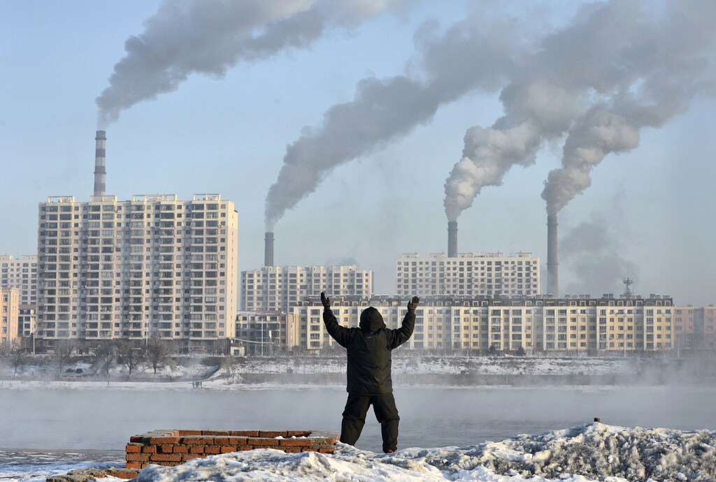 An elderly man exercises in the morning as he faces chimneys emitting smoke behind buildings across the Songhua river in Jilin, Jilin province, February 24, 2013. China's new rulers will focus on consumer-led growth to narrow the gap between rich and poor while taking steps to curb pollution and graft, the government said on Tuesday, tackling the main triggers for social unrest in the giant nation. Picture taken February 24, 2013. REUTERS/Stringer (CHINA - Tags: ENVIRONMENT BUSINESS POLITICS) CHINA OUT. NO COMMERCIAL OR EDITORIAL SALES IN CHINA - GM1E9351DC501