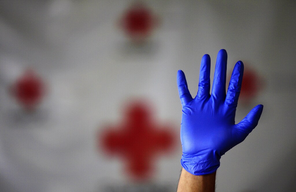 A Red Cross worker demonstrates how to properly wear and remove protective gloves during a training session with volunteers in Guatemala City April 29, 2009. Officials have said there have been no confirmed deaths from swine flu in Guatemala, which shares a border with Mexico.