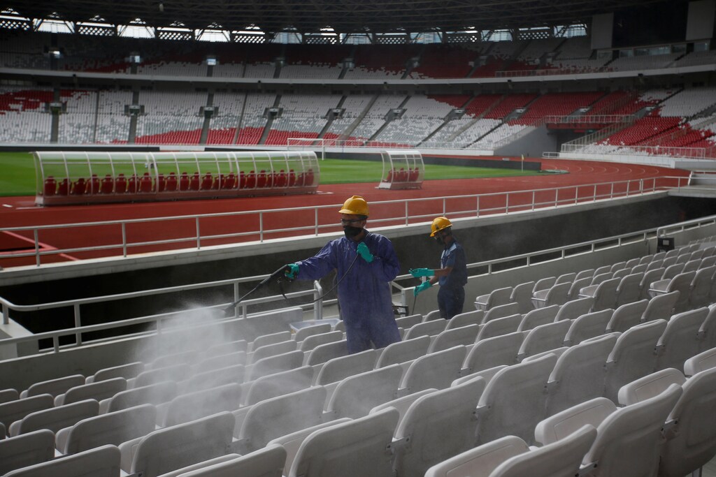 Workers spray disinfectant inside Gelora Bung Karno main stadium after Indonesia's capital began a two-week emergency period to prevent the spread of coronavirus disease (COVID-19) in Jakarta, Indonesia, March 26, 2020. REUTERS/Willy Kurniawan - RC2HRF9VQRQE