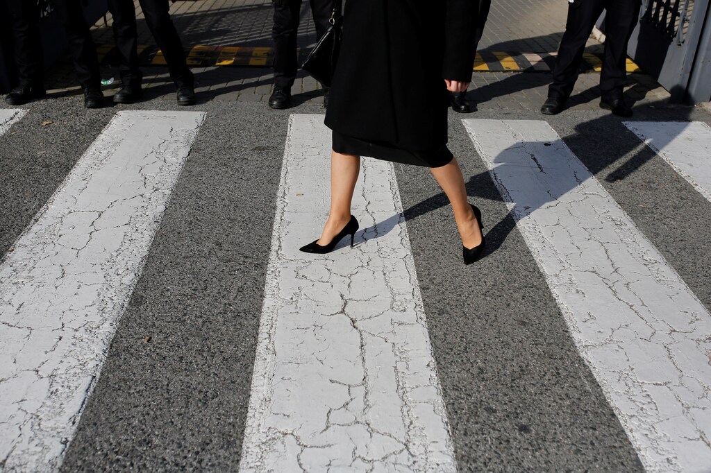 A woman walks between Spanish policemen and Women's rights groups during a protest against Andalusia government in Seville, Spain, January 15, 2019. REUTERS/Marcelo del Pozo - RC1859754F10