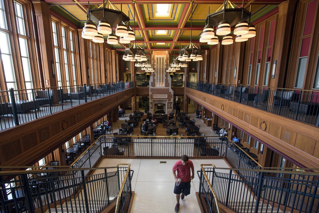 A student walks through Washington University's Tisch Commons as other students study and dine, in St. Louis, Missouri July 23, 2015. REUTERS/Adrees Latif - RTX1MUQ5