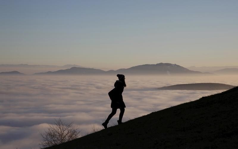 A woman walks on the Smetovi mountain range near Zenica, Bosnia and Herzegovina, December 20, 2015.
