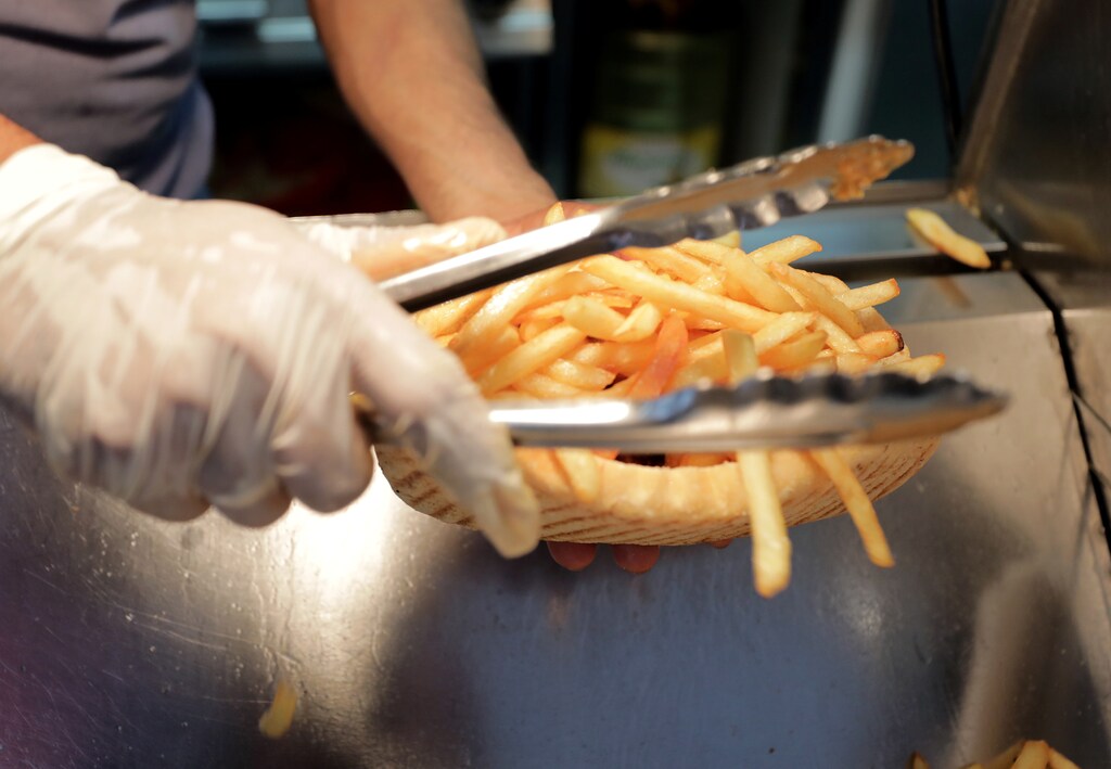 An employee prepares a sandwich with French fries at the Isla Burger Halal fast-food in Nice, France, September 25, 2017. REUTERS/Eric Gaillard - RC16C186D140