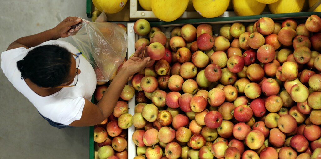 A consumer shops for apples at a market in Sao Paulo, Brazil January 11, 2017. REUTERS/Paulo Whitaker - RTX2YJ7E