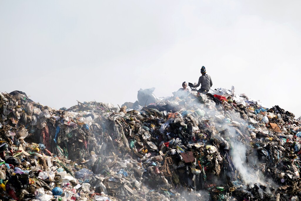 People collect recyclable items from a pile of rubbish at a landfill of Porto Romano, around 1 kilometre away from the sea line, in Durres, Albania July 19, 2018. REUTERS/Florion Goga - RC112F801860