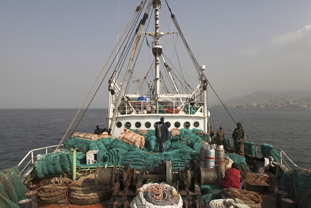 Sierra Leonean security forces supervise the crew on board a vessel apprehended for alleged illegal fishing activities in 2012.