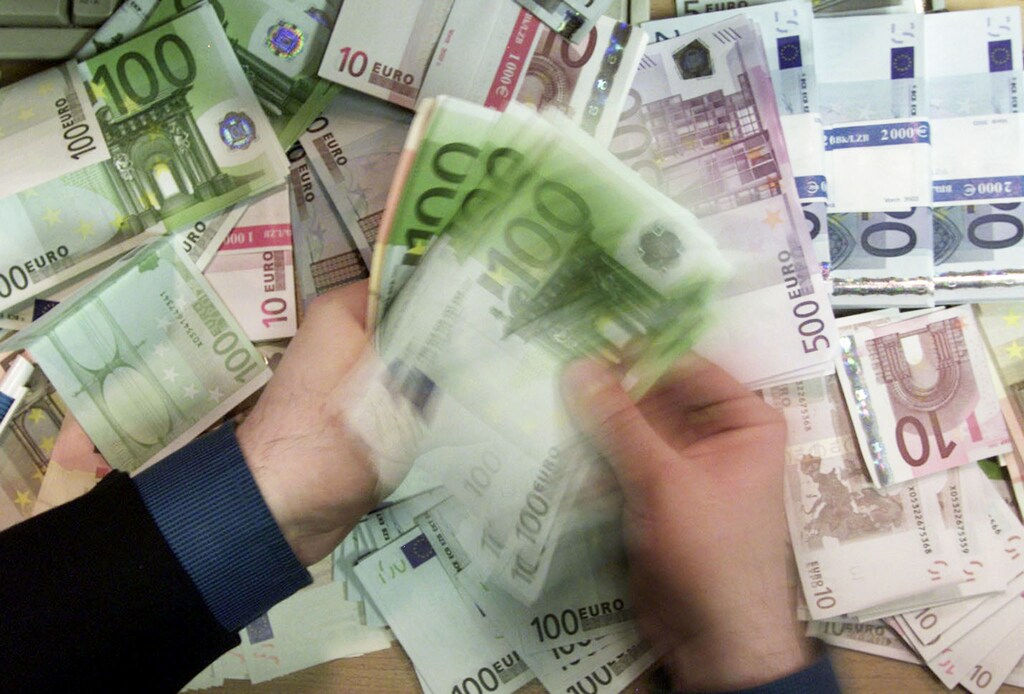 A London bank worker counts out euro bank notes as the first notes arrive in Britain's high street banks.