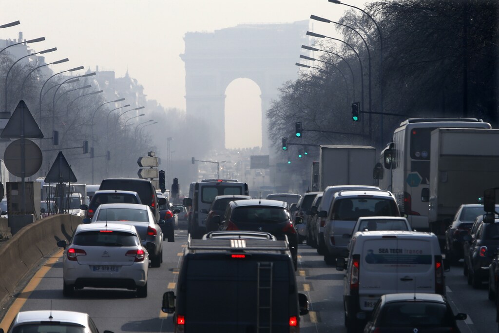 Rush hour traffic fills an avenue leading up to the Arc de Triomphe which is seen through a small-particle haze at Neuilly-sur-Seine, Western Paris, March 13, 2014 as warm and sunny weather continues in France. Residents and visitors to Paris basking in a streak of unseasonable sunshine were also being treated with a dangerous dose of particles from car fumes that pushed air pollution to levels above other northern European capitals this week. Swathes of France, including the French capital, were on maximum alert over air pollution on Thursday, prompting Paris authorities to make green transportation such as its Velib bike-share and the Autolib electric car fleet free for the day. REUTERS/Charles Platiau (FRANCE - Tags: ENVIRONMENT TRANSPORT TRAVEL) - PM1EA3D1A4F01