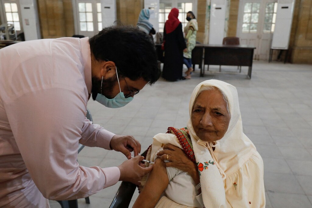 A woman receives a dose of the coronavirus disease (COVID-19) booster vaccine at a vaccination centre in Karachi, Pakistan December 13, 2021. REUTERS/Akhtar Soomro