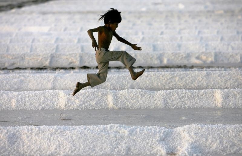 A worker's son plays in a salt pan near Bhavnagar, in the western Indian state of Gujarat March 5, 2009.