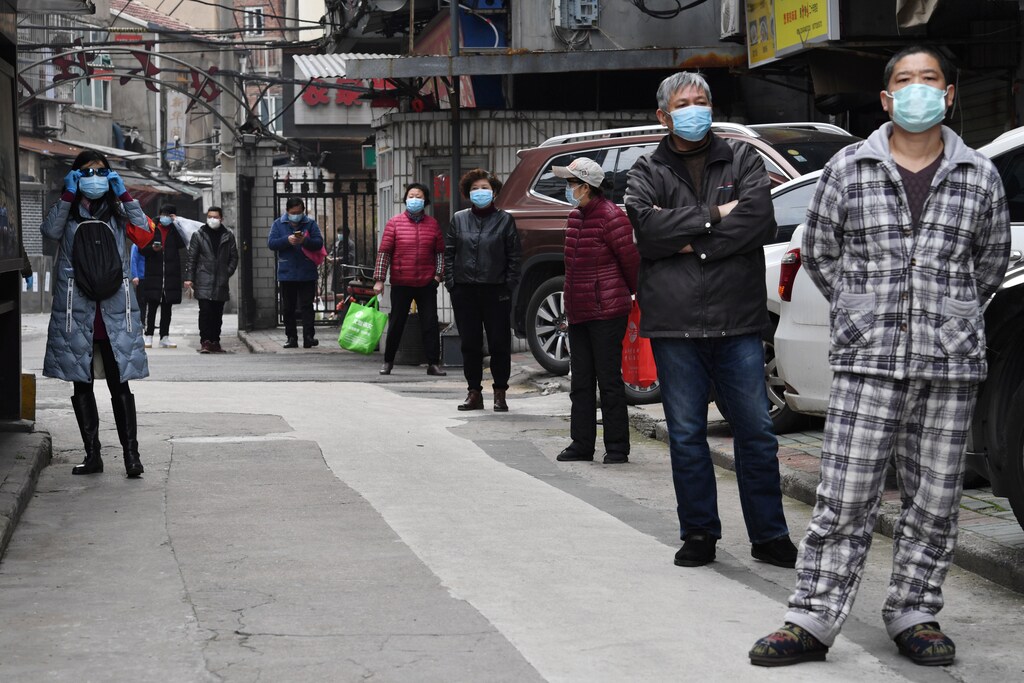 Residents line up to collect vegetables purchased through group orders at a residential area in Wuhan, the epicentre of the novel coronavirus outbreak, Hubei province, China March 5, 2020. REUTERS/Stringer CHINA OUT. - RC2PDF9U1064