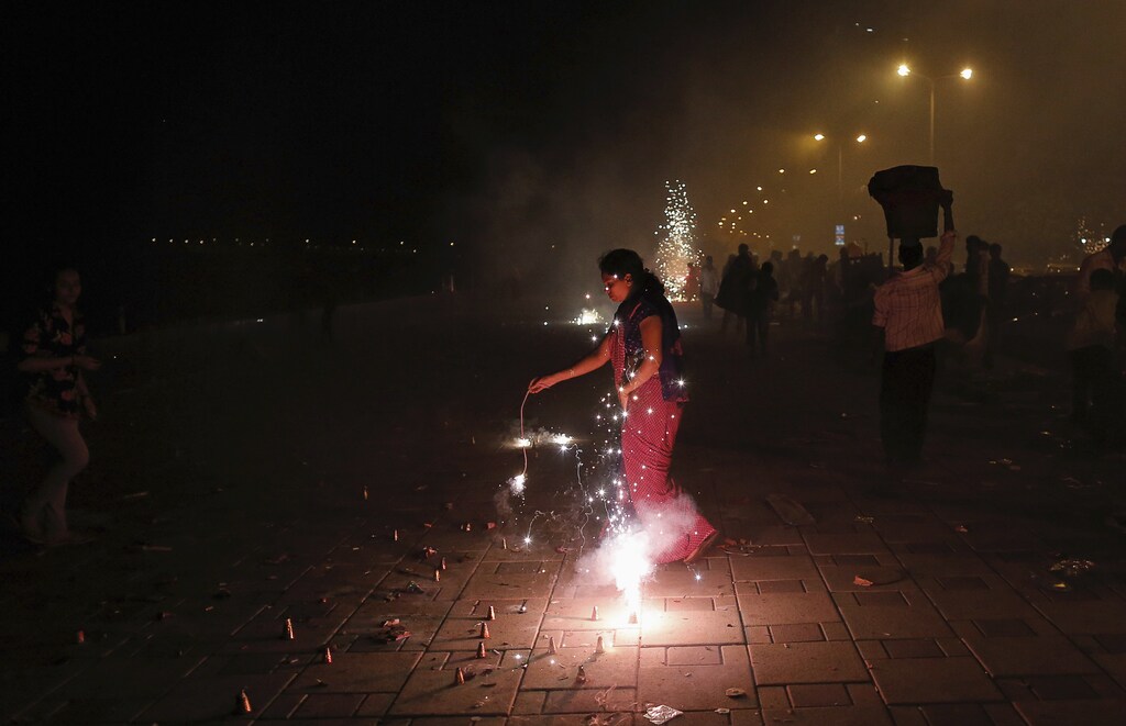 A woman lights firecrackers celebrating the Hindu festival of Diwali, the annual festival of lights, in Mumbai November 3, 2013. REUTERS/Danish Siddiqui (INDIA - Tags: RELIGION SOCIETY) - GM1E9B407PM01