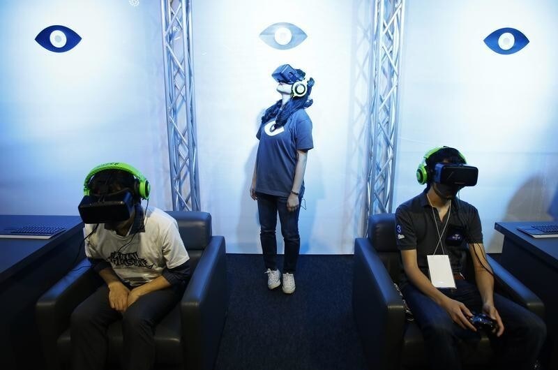 People try out Oculus VR's headset Oculus rift development kit 2 at its booth in Tokyo Game Show 2014 in Makuhari, east of Tokyo September 18, 2014. About 421 companies and organizations are participating in the Tokyo Games Show 2014, which will be held until September 21.