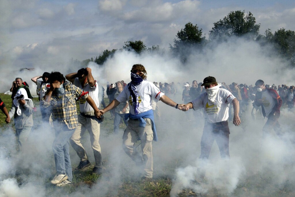 Anti GMO protesters clash with French police during a demonstration in a field in the small village of Valddevienne near Poitiers, France September 25, 2004. - PBEAHUOFTCF