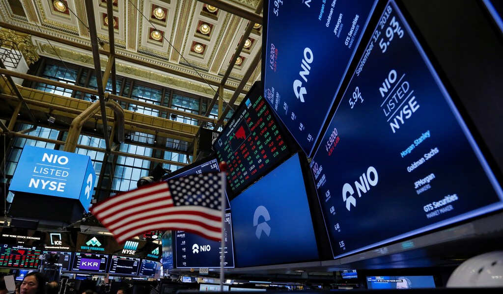 An American flag is seen among logos for Chinese electric vehicle start-up NIO Inc., on the trading floor of the New York Stock Exchange (NYSE) as NIO stock begins trading during the company's initial public offering (IPO) at the NYSE in New York, U.S., September 12, 2018. REUTERS/Brendan McDermid - RC1AD89AA640