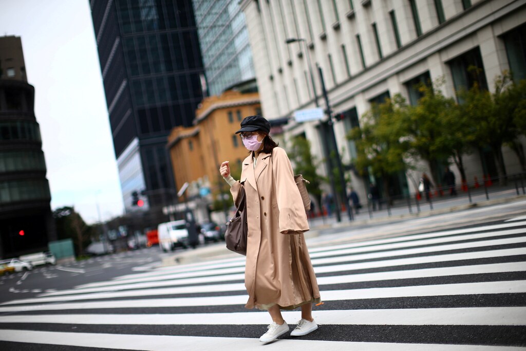 A woman, wearing protective face masks following an outbreak of the coronavirus disease (COVID-19), walks on a street in Tokyo, Japan March 9, 2020. REUTERS/Edgard Garrido - RC27GF9L0MB9