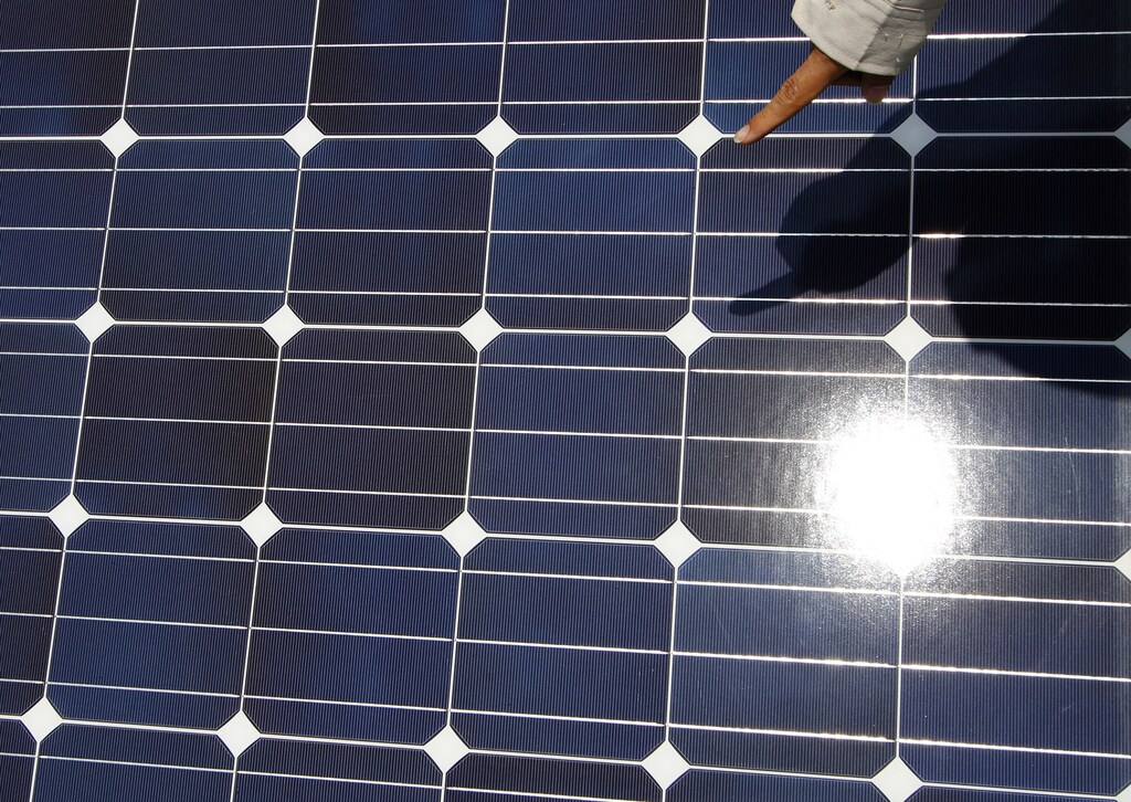 A worker checks solar panels at a solar power field in Kawasaki, near Tokyo July 6, 2011. Tokyo Electric Power Company, Inc. (TEPCO) and Kawasaki City are constructing the mega solar power field, consisting some 37,926 solar panels which will produce some 7.4 million kWh in a year. Commercial service will start on August, 2011. REUTERS/Toru Hanai (JAPAN - Tags: BUSINESS ENERGY ENVIRONMENT) - GM1E77619B401