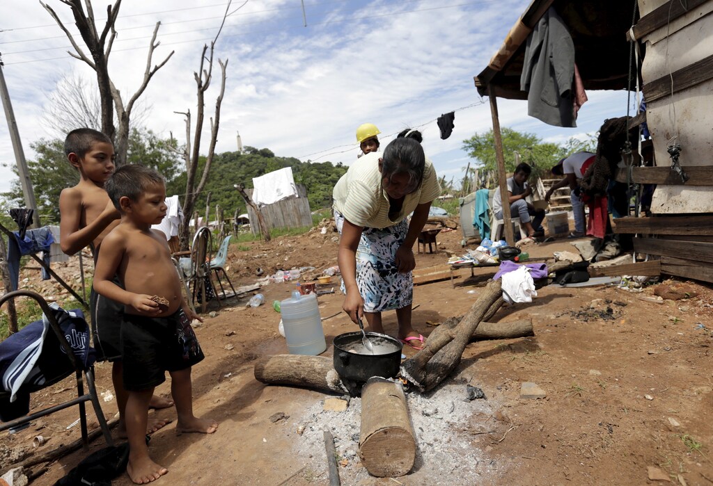 A Paraguayan woman cooks in one of Paraguay's poor neighborhoods in Asuncion, March 31,2015. Paraguay's government announced that the poverty index rose in 2014 over the previous year, a tendency that goes against the government's official goal of improving the standard of living.