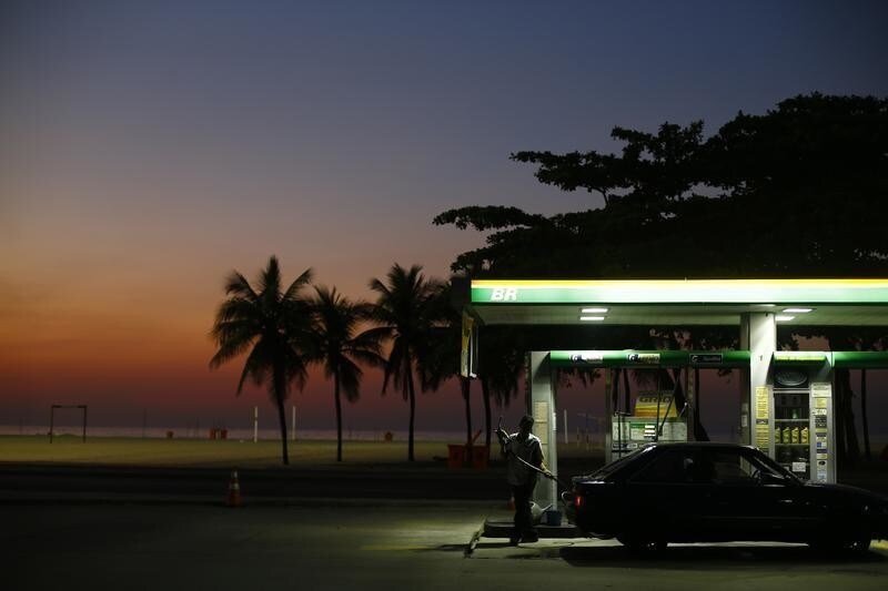 A worker prepares to fill a car at a gas station close to Copacabana beach in Rio de Janeiro, January 12, 2015. Reuters photographers from Mali to Mexico have shot a series of pictures of fuel stations. Whether it is plastic bottles by the roadside in Malaysia or a futuristic forecourt in Los Angeles, fuel stations help define our world. Oil prices steadied above $48 a barrel on Tuesday, recovering from earlier losses as the dollar weakened against the euro. Oil prices have dropped nearly 60 percent since peaking in June 2014 on ample global supplies from the U.S. shale oil boom and a decision by OPEC to keep its production quotas unchanged. REUTERS/Ricardo Moraes (BRAZIL - Tags: TRANSPORT BUSINESS COMMODITIES ENERGY TPX IMAGES OF THE DAY)ATTENTION EDITORS: PICTURE 01 OF 26 FOR WIDER IMAGE PACKAGE 'AT THE PUMP - THE WORLD FILLS UP' SEARCH 'WORLD FILLS UP' FOR ALL IMAGES - LM2EB1Q1FY901