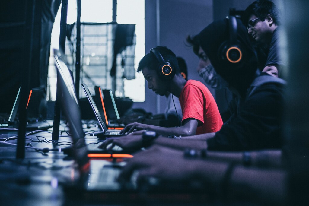 Young people in headsets on laptops