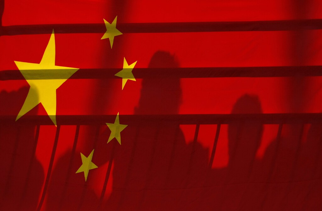 The shadows of spectators are seen through a Chinese national flag during the men's kayak (K1) semifinal at the Beijing 2008 Olympic Games August 12, 2008. REUTERS/Phil Noble (CHINA) - BR2E48C0SY2EC