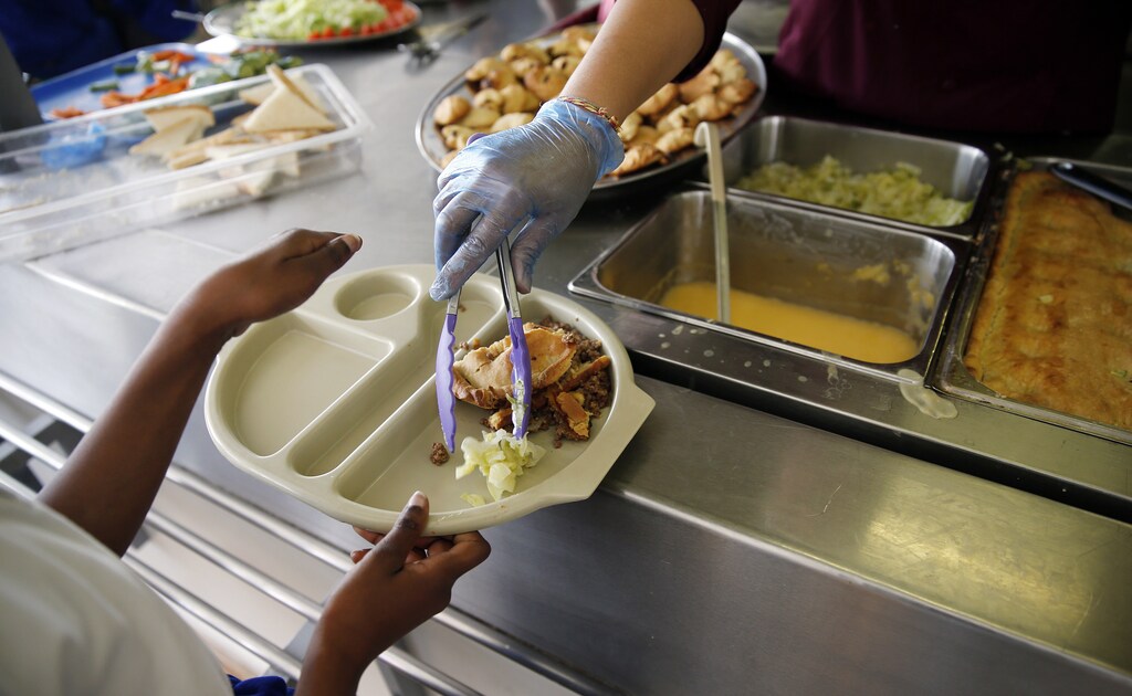 A student receives her lunch at Salusbury Primary School in northwest London June 11, 2014. This September, a new government scheme plans to give free meals to all reception, year 1 and 2 students registered in England's state-funded schools. Local media reports that this will amount to saving families about ?400 a year per child. REUTERS/Suzanne Plunkett (BRITAIN - Tags: EDUCATION SOCIETY FOOD) - GM1EA6B1O5X01