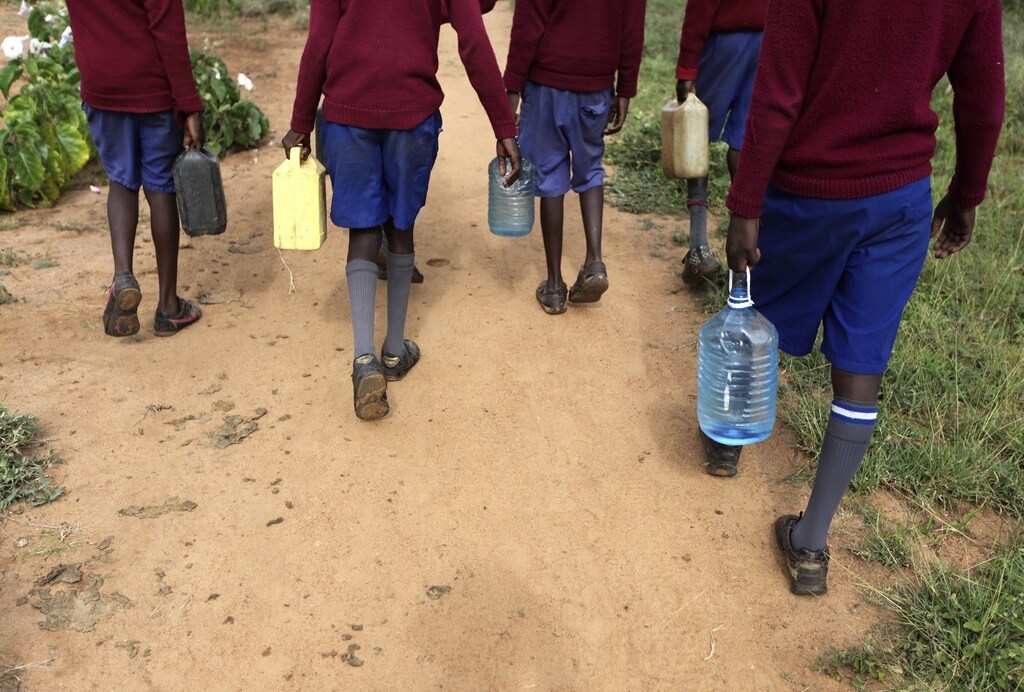 Boys from Nalepo Primary School carry water collected in plastic bottles and cans as they walk back to their school in the semi-arid Kajiado County, south of Kenya's capital Nairobi, June 12, 2012. The school depends on students to fetch water before coming to class, and drought conditions have forced enrolment at the school to decrease as people migrate looking for greener pastures, headteacher Benjamin said. The lack of water disrupts lessons as students struggle to catch up with their classmates after fetching water, and lose their concentration when the water shortage deprives them of food. By 2025, two-thirds of people worldwide are expected to face water shortages as businesses, agriculture and growing populations compete for the ever more precious commodity. Picture taken June 12, 2012. REUTERS/Noor Khamis (KENYA - Tags: EDUCATION ENVIRONMENT SOCIETY) - RTR358IT