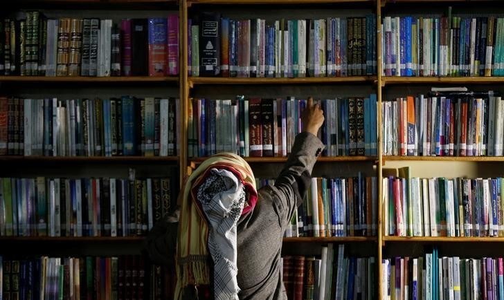 Yemeni author Mohammed al-Qaoud picks a book at a library in Sanaa, Yemen April 18, 2018. Picture taken April 18, 2018. REUTERS/Khaled Abdullah