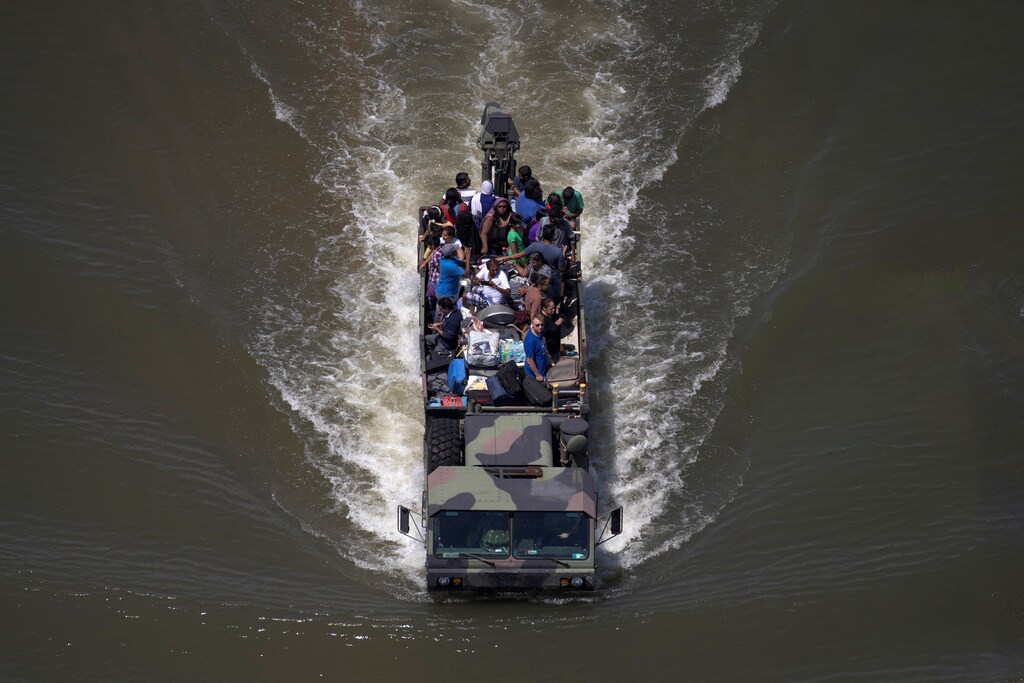 A military vehicle evacuates residents from the Autumn Chase Park apartments while pushing its way through flood waters caused by Tropical Storm Harvey in Port Arthur, Texas, U.S. August 31, 2017. REUTERS/Adrees Latif - RC15A408DEA0